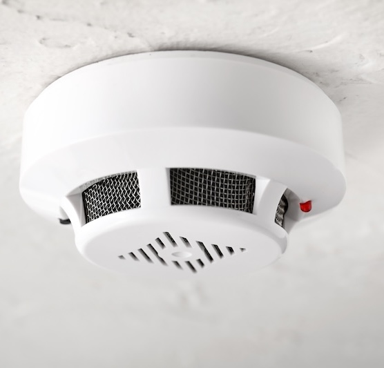 Modern smoke detector on ceiling